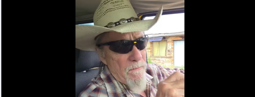 Fostoria News Man wearing cowboy hat and sunglasses inside vehicle.